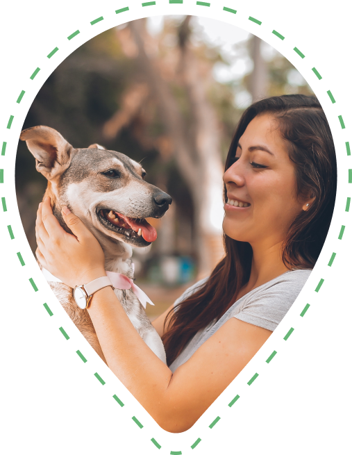 An image of a young woman looking affectionately at her dog whilst stroking its neck.